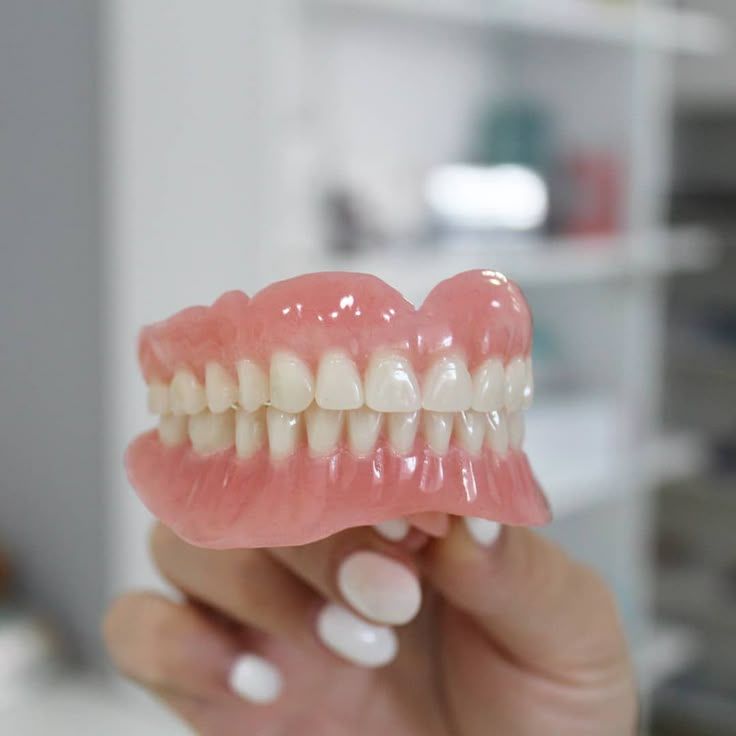 Dentist fitting and adjusting patient dentures